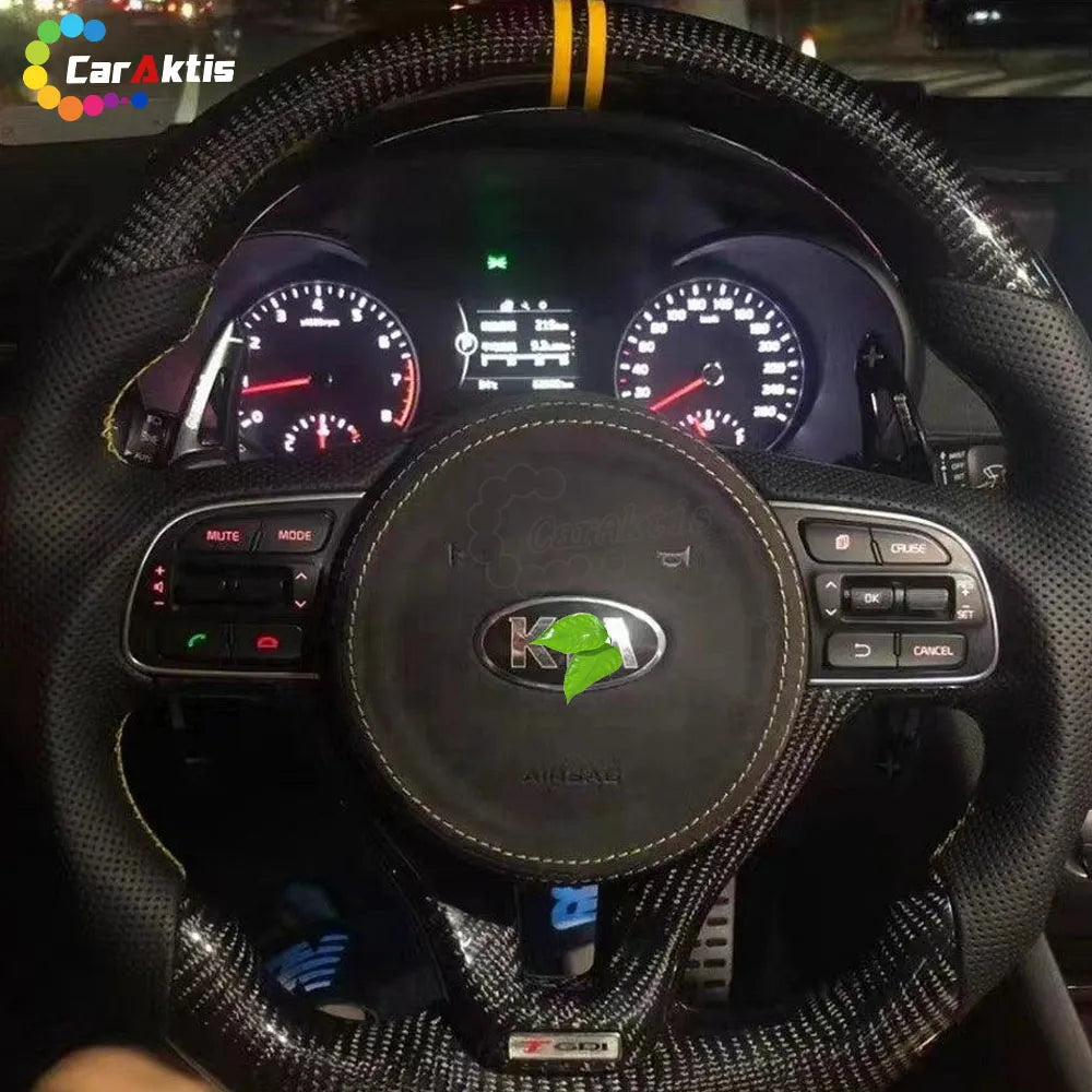 Interior view of a 2016-2020 Kia Optima featuring an installed custom steering wheel with glossy black carbon fiber and premium black perforated leather for a sleek, OEM+ look.