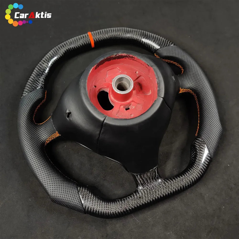 Rear view of custom Porsche 996 carbon fiber steering wheel showing the hub connection and orange stitching detail.