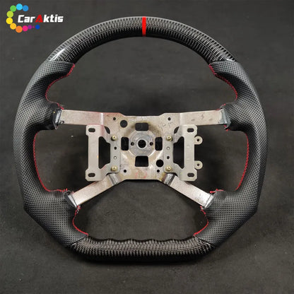Front view of the steering wheel frame for Mitsubishi 3000GT with black perforated leather and red stitching.