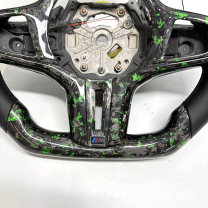This custom BMW steering wheel is crafted from premium forged carbon fiber, showcasing a unique, close-up marble-like texture.