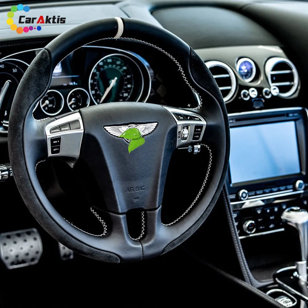 Interior view of a Bentley Continental GT with a custom Alcantara and carbon fiber steering wheel installed in the luxury cabin.
