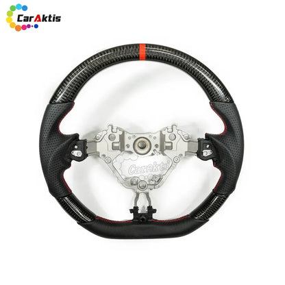 Top-down view of a custom D-shape steering wheel combining glossy carbon fiber and breathable leather.