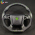 Custom steering wheel for Chevy Silverado featuring exotic green flake forged carbon fiber and black perforated leather grips with green contrast stitching.