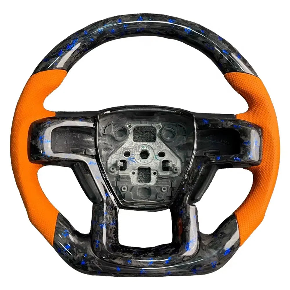 Close-up of the premium orange perforated leather grips on a Ford Raptor steering wheel, perfect for matching the factory Code Orange interior accents.