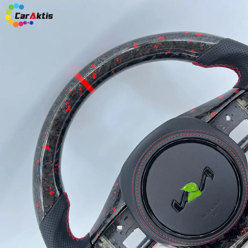 Close-up of glossy carbon fiber and black leather steering wheel with red stitching for Kia K5 Optima.