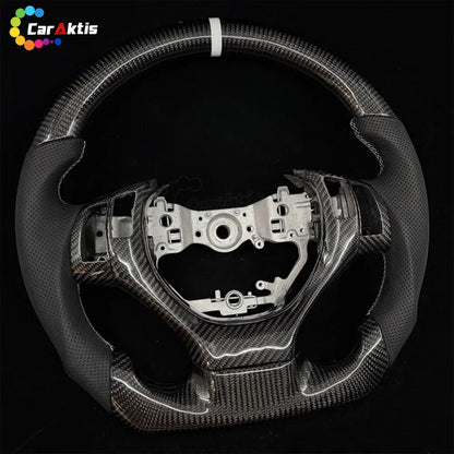 Lexus carbon fiber steering wheel, highlighting the ergonomic side grips and the deep shine of the carbon fiber weave.