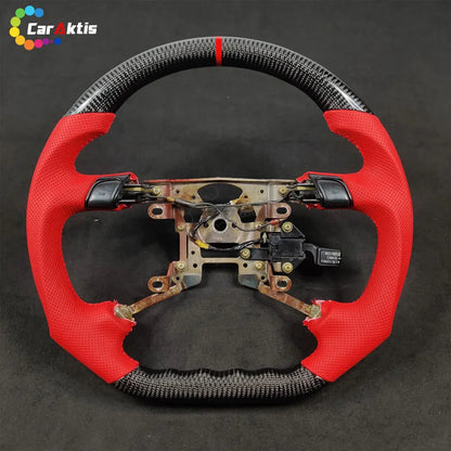 Mitsubishi 3000GT custom steering wheel frame with vibrant red perforated leather side grips and carbon fiber top/bottom.
