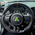 Installed custom carbon fiber steering wheel on Mitsubishi Lancer Evo X dashboard showing paddle shifters and gauges.