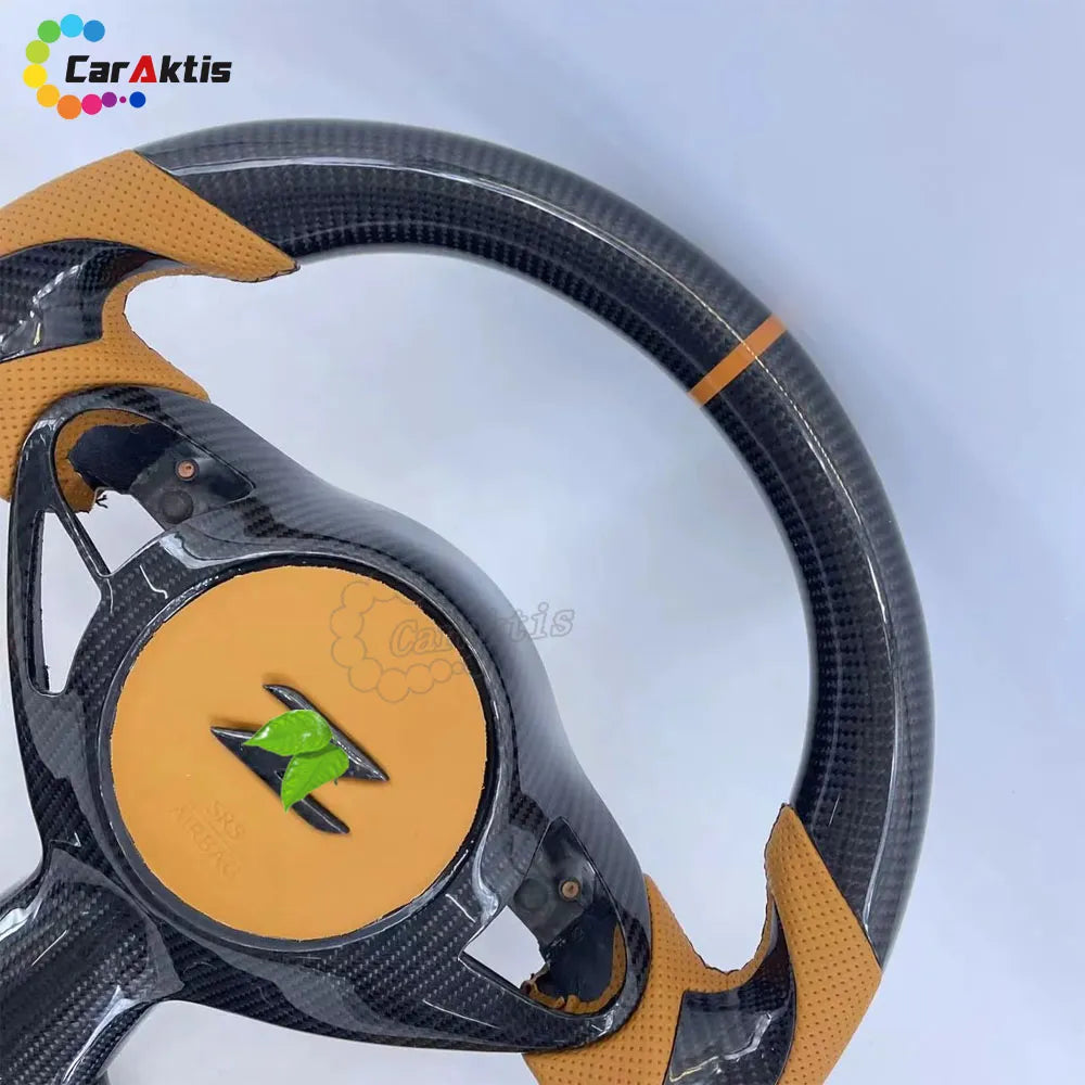 Glossy carbon fiber steering wheel for Nissan 370Z featuring an orange center racing stripe and tan leather.