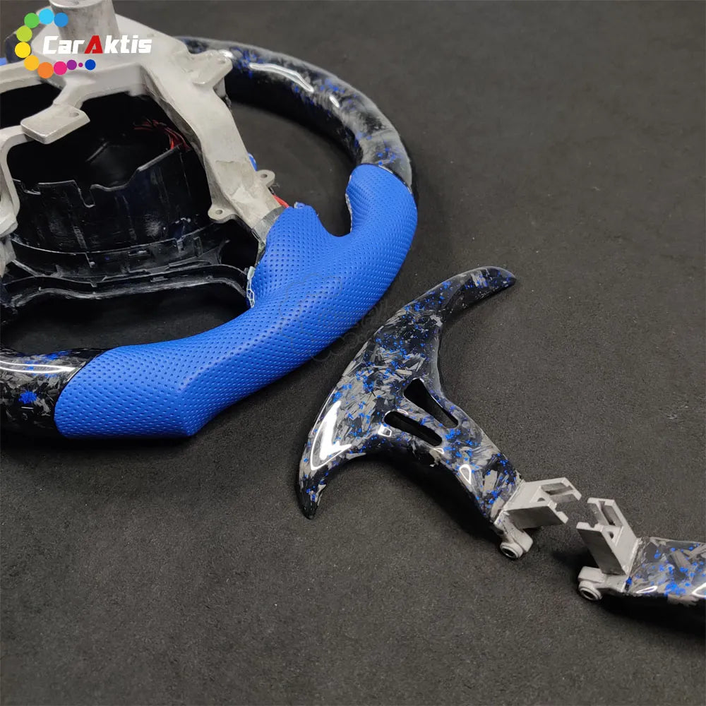 Close-up of custom forged carbon fiber shift paddles with blue accents for 2008-2016 Nissan GT-R R35.