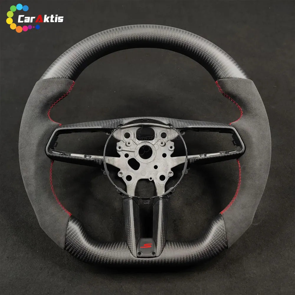 Custom steering wheel for Porsche 911 992 made of Alcantara and carbon fiber with red "S" logo and stitching.