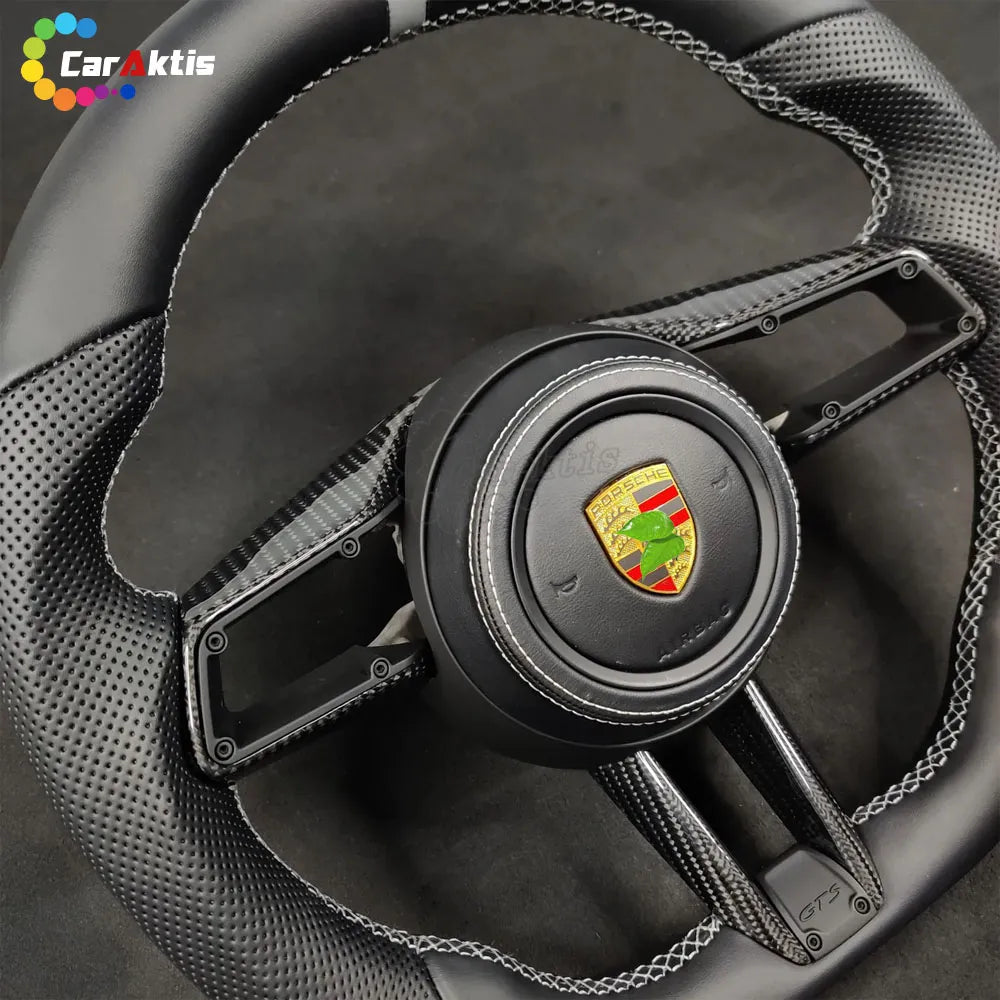 Porsche 992 style custom carbon fiber steering wheel with smooth black leather and white contrast stitching.