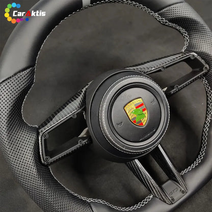 Porsche 992 style custom carbon fiber steering wheel with smooth black leather and white contrast stitching.