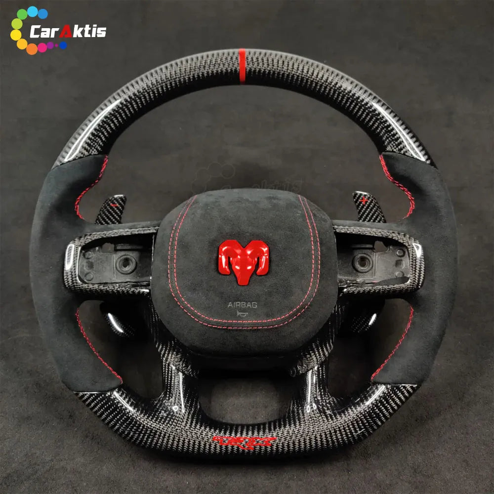 Glossy twill weave carbon fiber steering wheel for Ram TRX with red Ram head logo and perforated leather-style grips