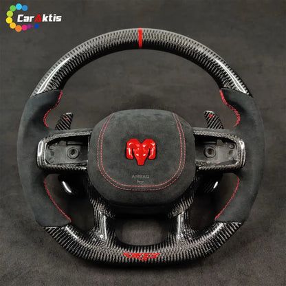 Glossy twill weave carbon fiber steering wheel for Ram TRX with red Ram head logo and perforated leather-style grips