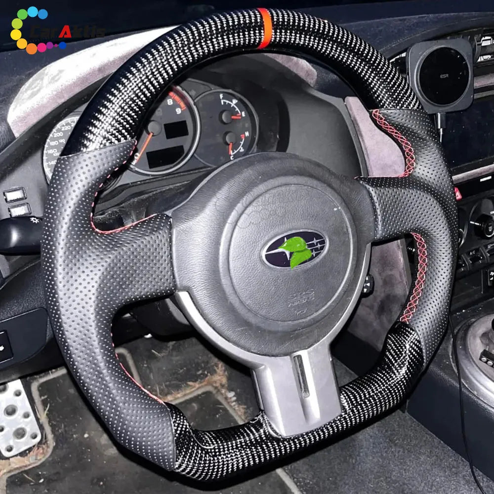Stealth look all-black carbon fiber steering wheel with black perforated leather for a clean Subaru BRZ interior.