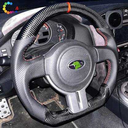 Stealth look all-black carbon fiber steering wheel with black perforated leather for a clean Subaru BRZ interior.