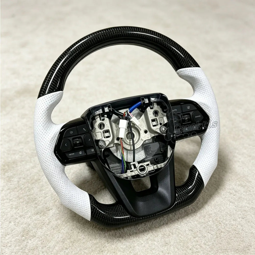 Glossy carbon fiber steering wheel for Toyota Hilux featuring handcrafted white perforated leather grips for enhanced comfort and luxury aesthetics.