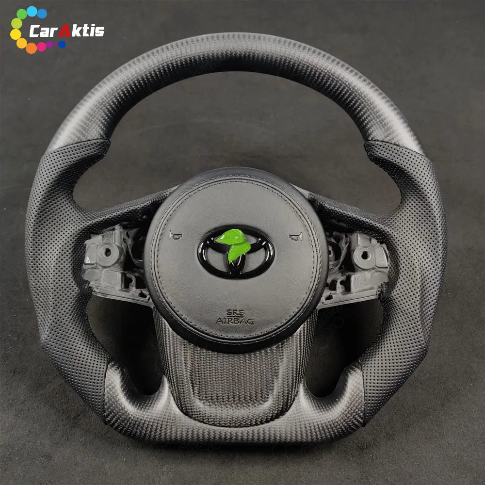 Ergonomic D-shape flat bottom steering wheel in matte carbon fiber for the 2019-2026 Toyota Supra.