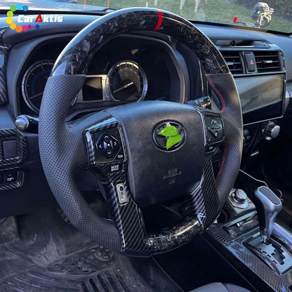 Installed view of a forged pattern carbon fiber steering wheel in a Toyota Tacoma.