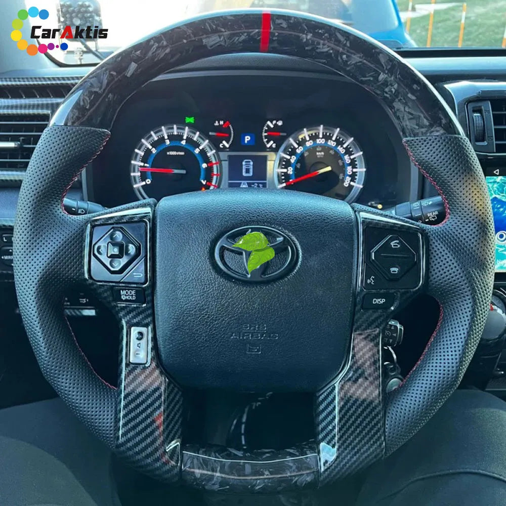 Close-up of a forged carbon fiber steering wheel with perforated leather installed in a Tundra.