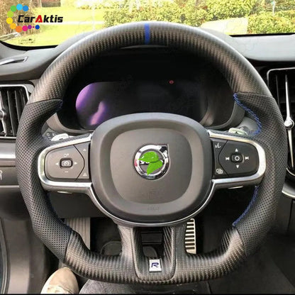 Installed view of a Custom Carbon Fiber Steering Wheel with Blue Center Stripe in a Volvo interior.