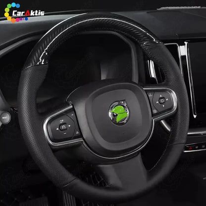 Interior view of a Volvo XC60 equipped with a glossy carbon fiber and leather steering wheel, showing airbag and button integration.